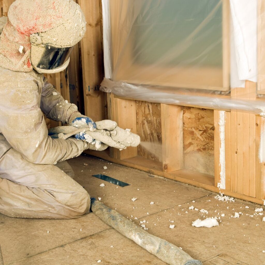 person spraying spray foam insulation in a home.