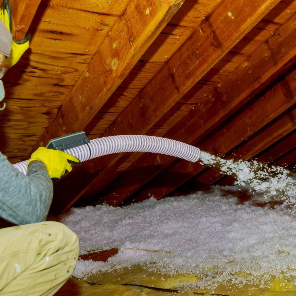 Spray foam insulation being sprayed into an attic.