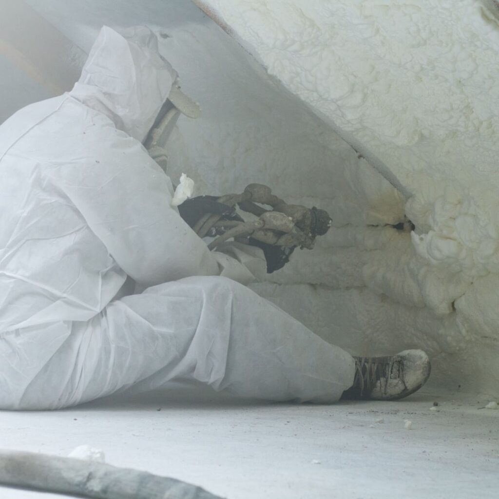 Spray foam insulation being sprayed into a crawl space.