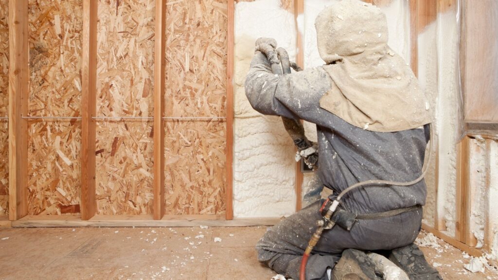 Person spraying foam insulation