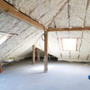 A clean, finished attic with the roof deck fully encapsulated in spray foam insulation, creating a conditioned space.
