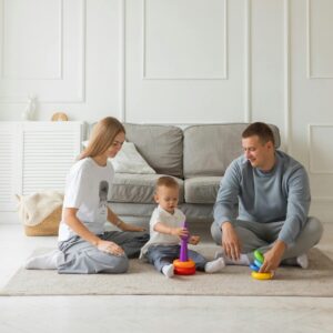 A happy young family with a toddler plays comfortably on the floor of their well-insulated living room.