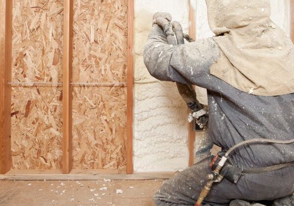 Person spraying white spray foam on a wall
